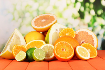 Lots ripe citrus on wooden table on natural background