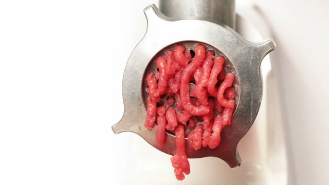 Closeup action of mincer machine with fresh chopped meat