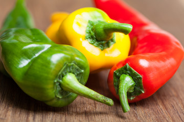 Ausschnitt von bunten Paprikas auf Holz