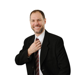 Smiling man in a suit straightens his tie isolated on white