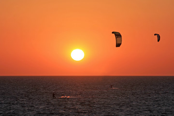 kitesurfers at sunset