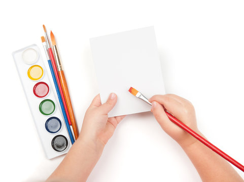 blank sheet in child hand with watercolor brush