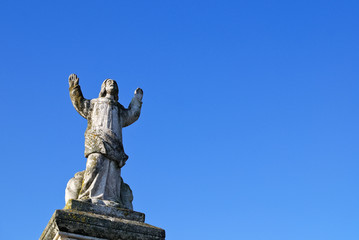 Fototapeta premium Statue Mann betet Richtung Himmel