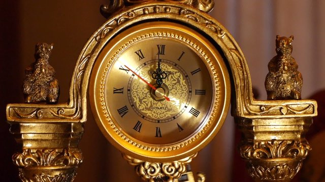 The arrows of the antique clock show 12:00.