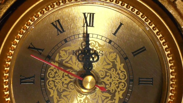 The arrows of the antique clock show 12:00. Clode-up shot.