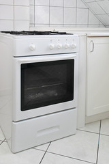 Fototapeta premium White gas cooker in white tiled kitchen