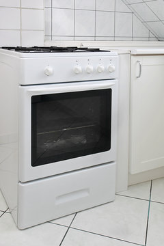White gas cooker in white tiled kitchen