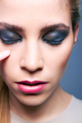 Closeup portrait of beautiful woman with amazing makeup in studi