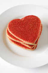 Sugar coated valentine day cookies in a white plate.