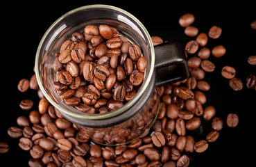Fototapeta premium Modern mug made of glass with coffee beans on black background