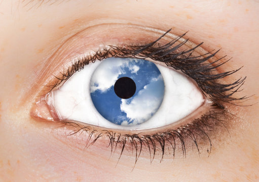 surrealistic picture of a woman's  eye with the sky in it