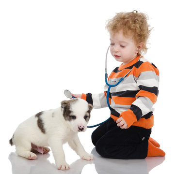 child examining dog and listening with stethoscope