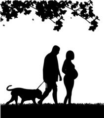 Pregnant woman and her husband walking with his dog