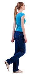back view of walking  woman  in  gray jeans.