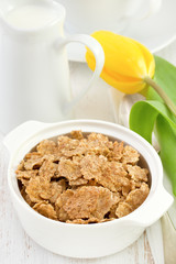 flakes in white bowl with spoon and yellow tulip