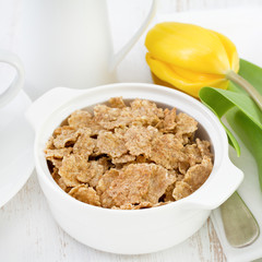 flakes in white bowl and yellow tulip