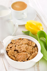 flakes in the bowl with coffee and yellow tulip