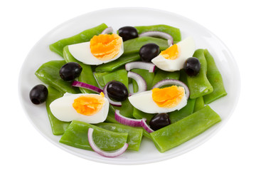 salad with boiled beans and egg on the plate on white background