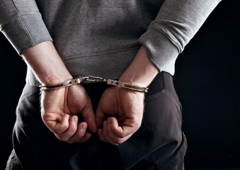Outlaw's Hands Locked in Handcuffs
