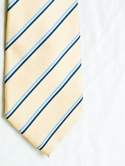 A striped yellow and blue tie isolated on white background.