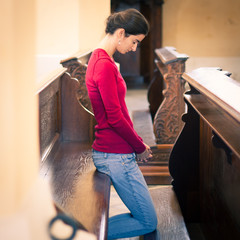 Young woman praying in a church