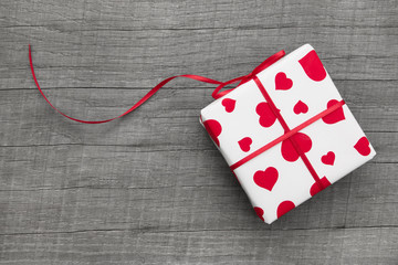 Ein Geschenk mit rot weißem Papier und Herzen zum Valentinstag