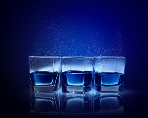 Three glasses of blue liquid