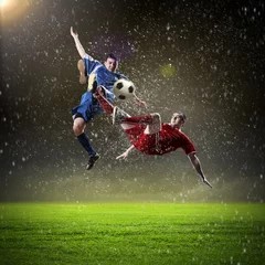 Fotobehang twee voetballers die de bal slaan © Sergey Nivens