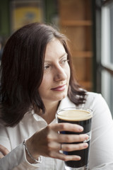 Young Woman with Beautiful Brown Eyes Drinking a Pint of Stout