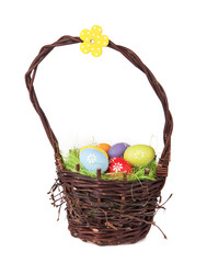 Easter basket with colored eggs, isolated on white background