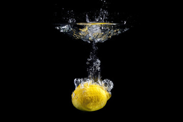 Fresh fruit dropped into water with splash on black background © filipobr