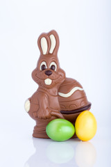 Osterhase aus Schokolade mit Ostereiern vor weißem Hintergrund