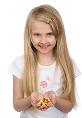 little girl holding some pills. isolated on white