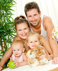 Young happy family with a pet rabbit