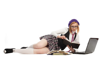 Girl with books and laptop, lying on a white background.