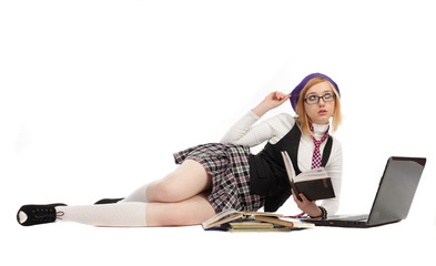 Girl with books and laptop, lying on a white background.