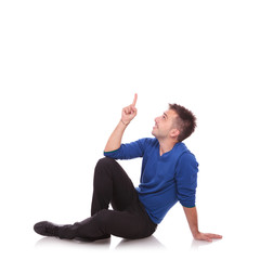 young casual man pointing up