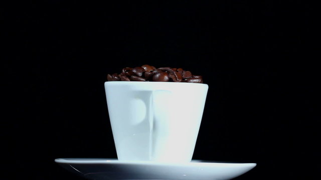 White cup with a saucer and coffee grains