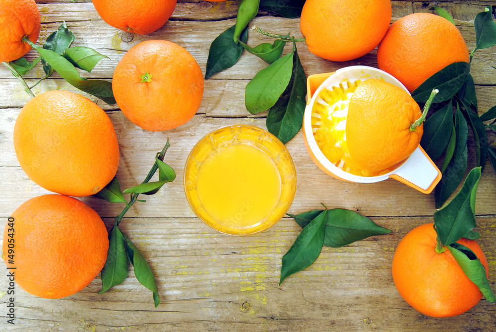 Wall mural squeezed citrus juice on wood background and oranges