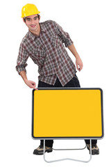 Construction worker pointing to a blank yellow sign