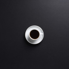 Close-up image of a white coffee cup on a black table