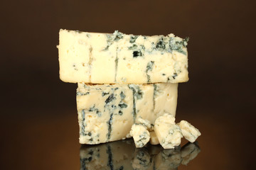 Cheese with mold on brown background close-up