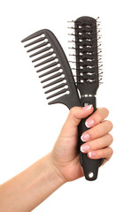 Three combs in female hand, isolated on white