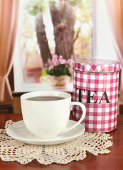 Jar and cup of tea on table in room