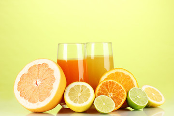 Lots ripe citrus with juices on green background