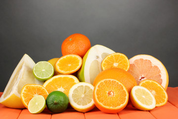 Lots ripe citrus on wooden table on black background
