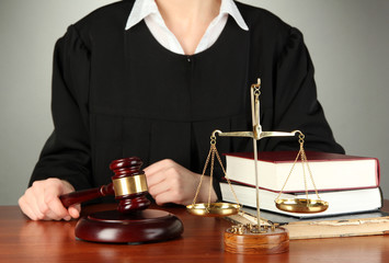 Judge sitting at table during court hearings on grey background