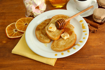 White bread toast with honey and cup of coffee on wooden table