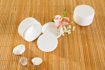 Empty cream jars on bamboo mat