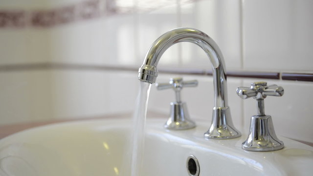 Water running from a chrome tap faucet
